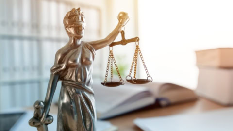 Fernstudium Rechtswissenschaften: Schmuckbild zur Studiengangsseite, enthält eine Statue Justitias auf einem Schreibtisch.